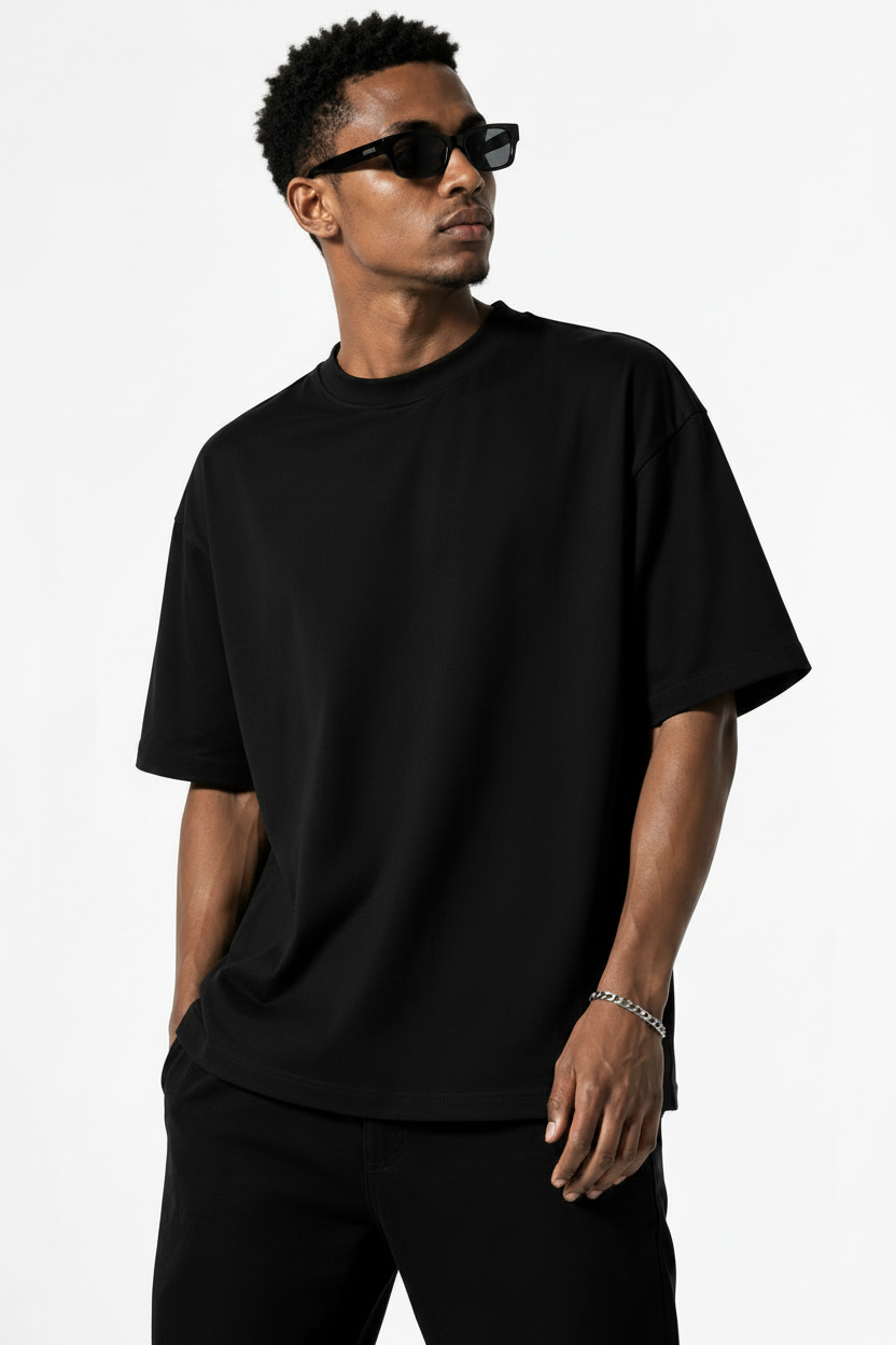 A man wearing an oversized black half sleeve t-shirt