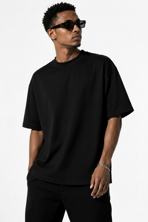A man wearing an oversized black half sleeve t-shirt