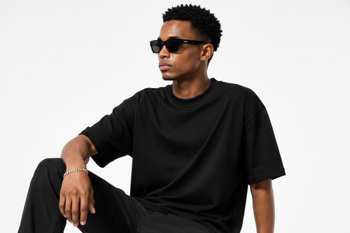 A man wearing an oversized black half sleeve t-shirt .